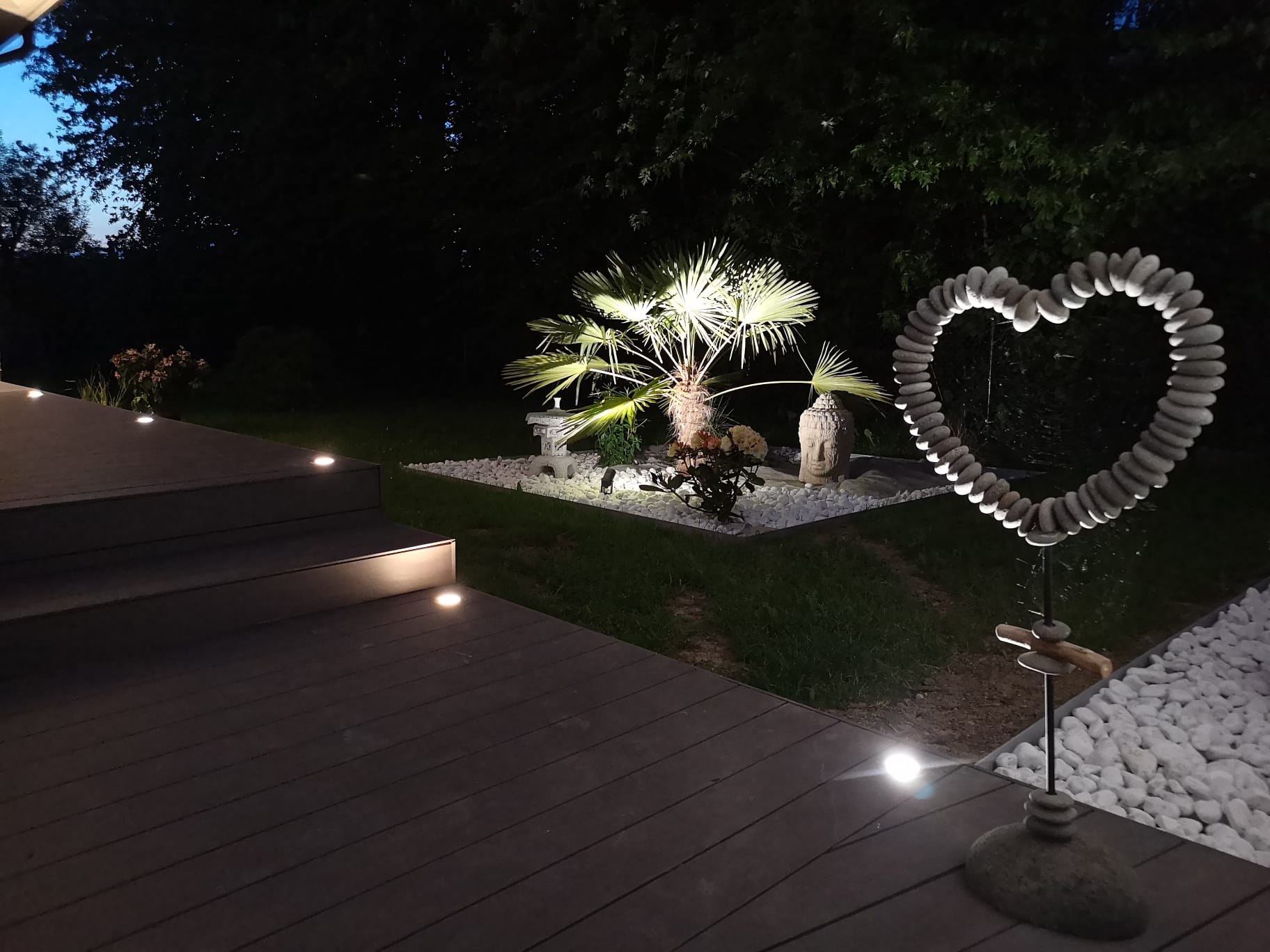 Jardin paysager éclairé avec palmier, balisage LED et décoration lumineuse